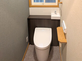 トイレリフォーム 収納スペースが増えてスッキリとした、シックな印象のレストルーム